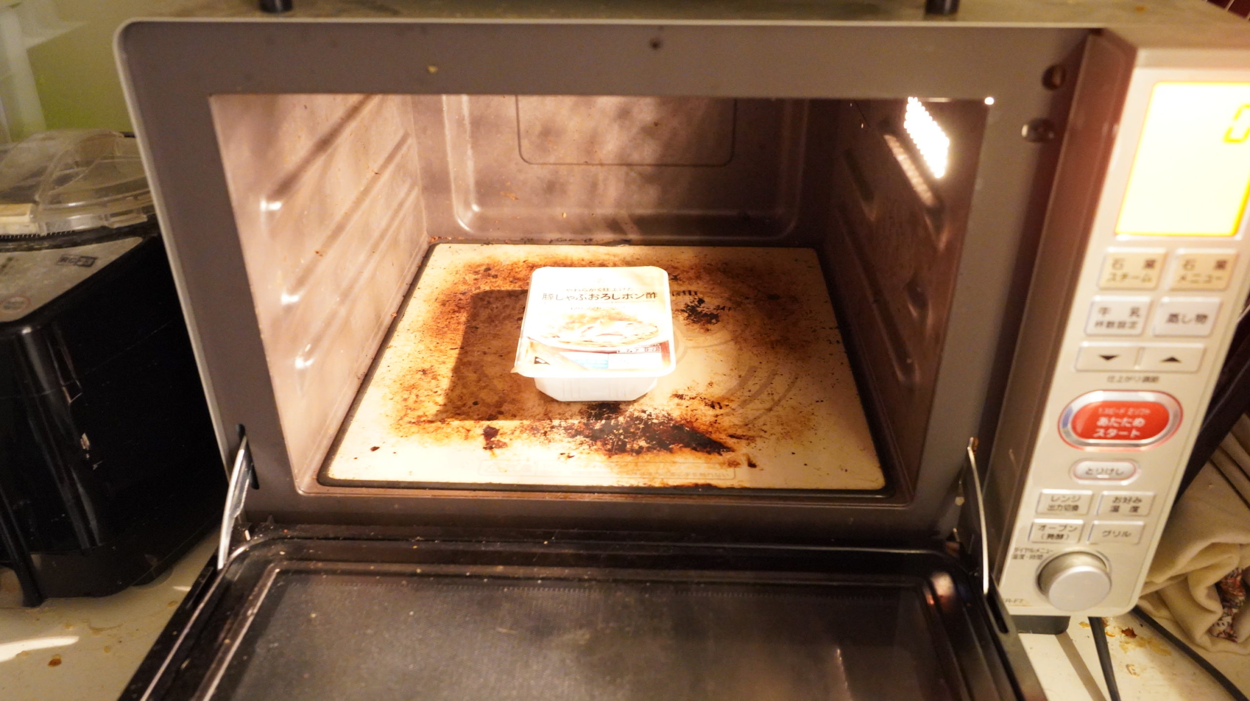 セブンイレブンの冷凍食品「やわらかく仕上げた豚しゃぶおろしポン酢」を電子レンジで加熱している写真