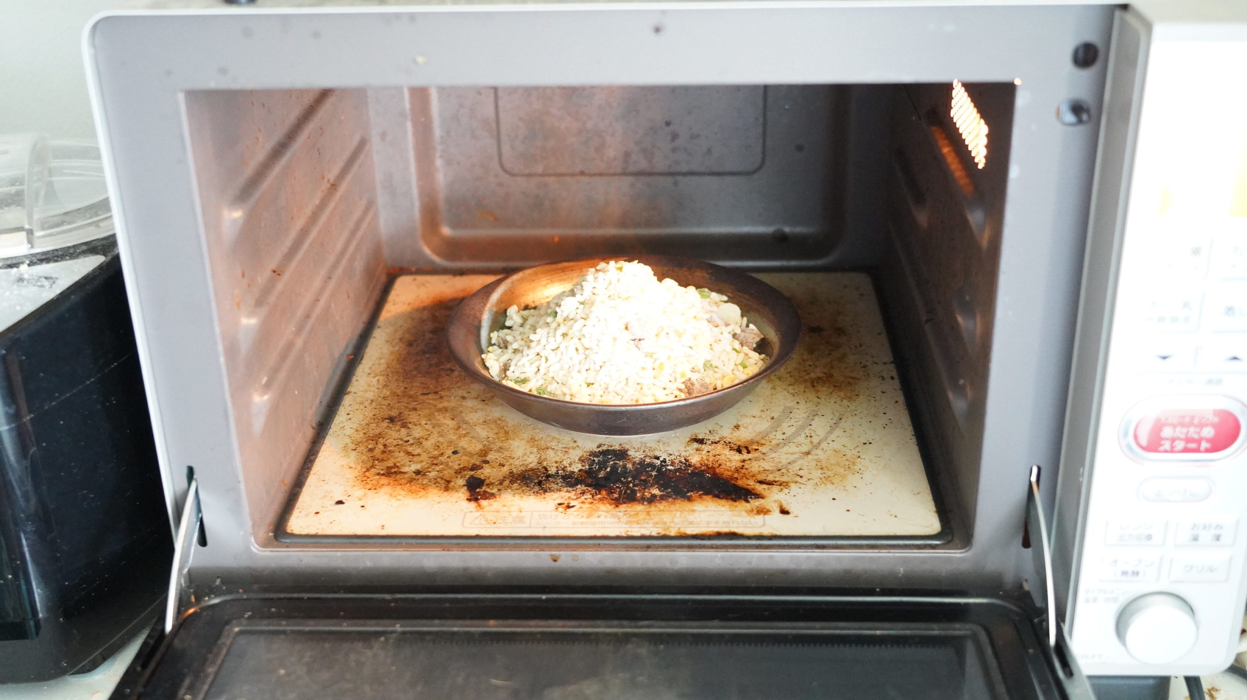 味の素の冷凍食品「焦がしにんにくのマー油と葱油が香るザ★チャーハン」を調理している写真