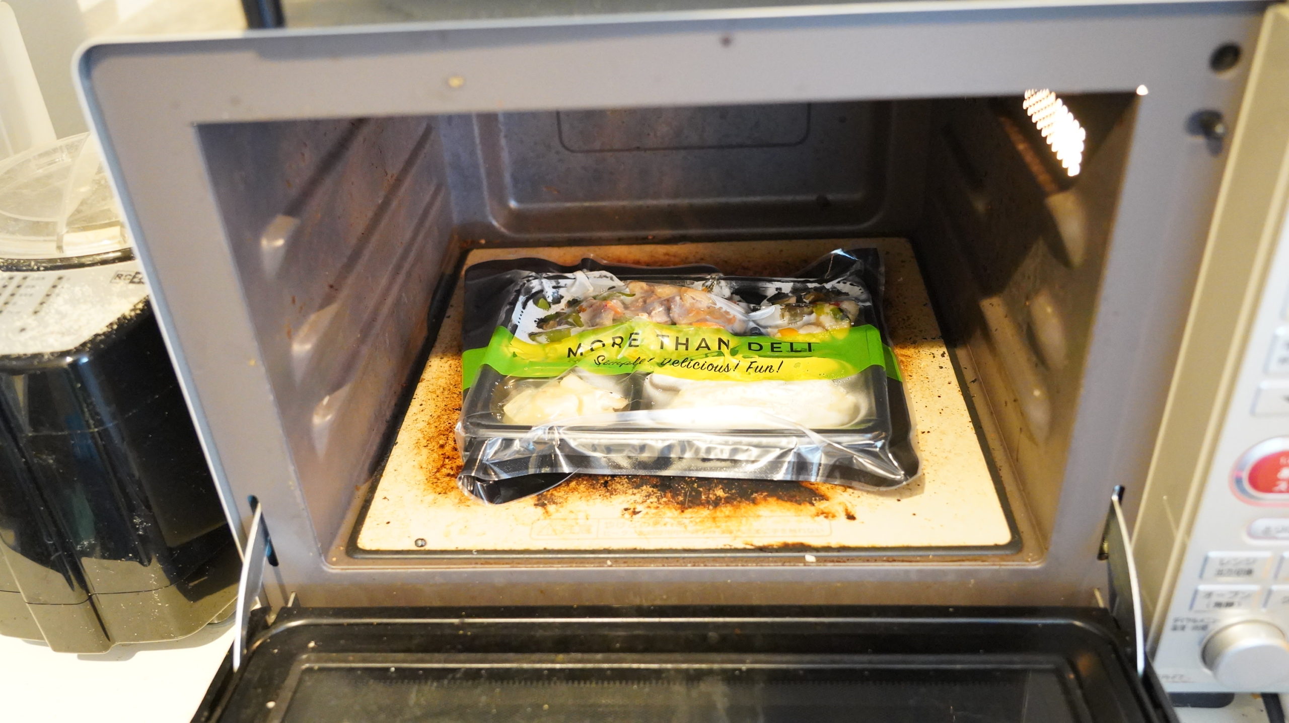 More than Deli（モアザンデリ）の冷凍弁当「牛肉のオイスターいため」を電子レンジで加熱している写真
