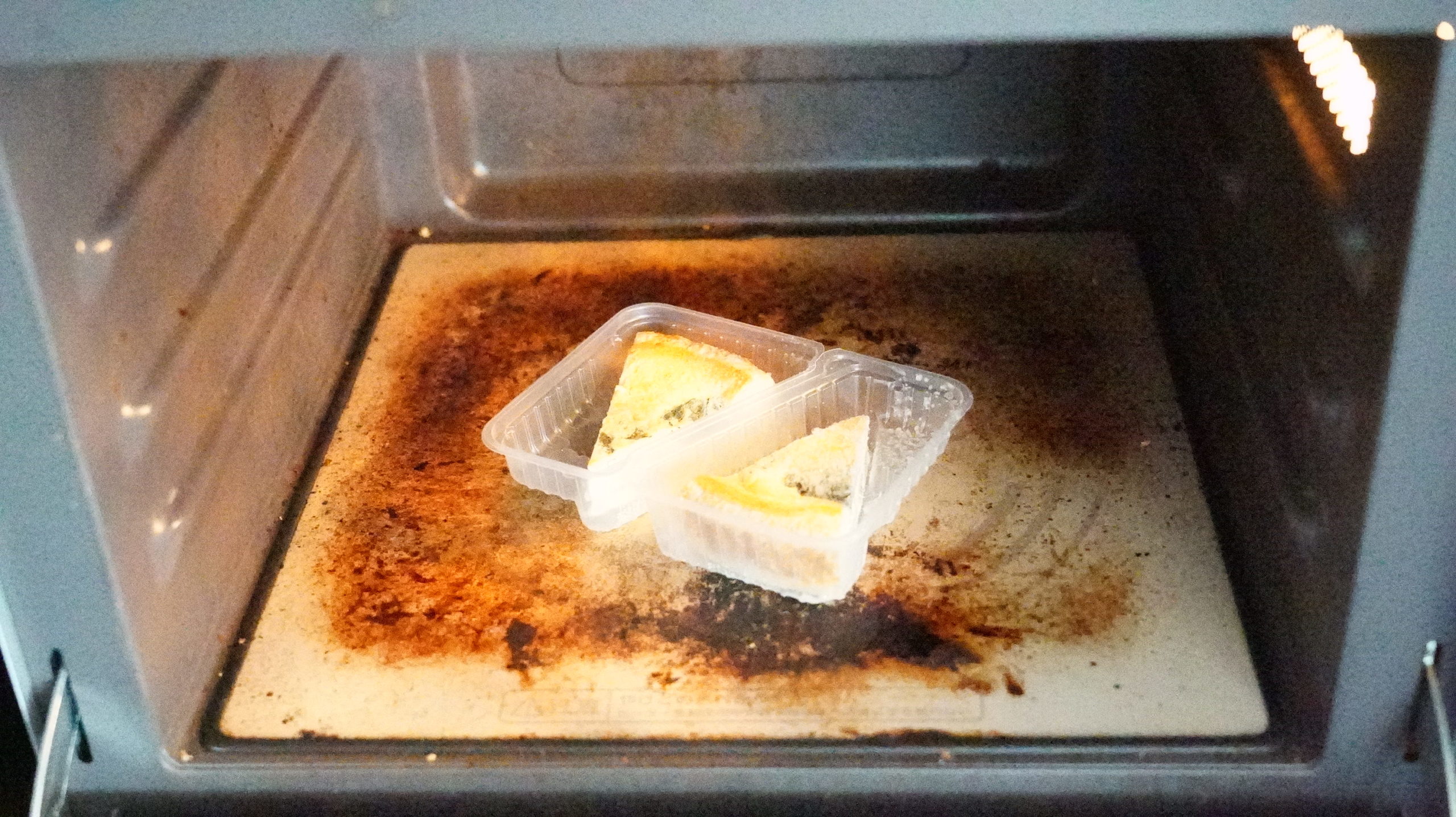 ローソンの冷凍食品「ベーコンとほうれん草のキッシュ」を電子レンジで加熱している写真
