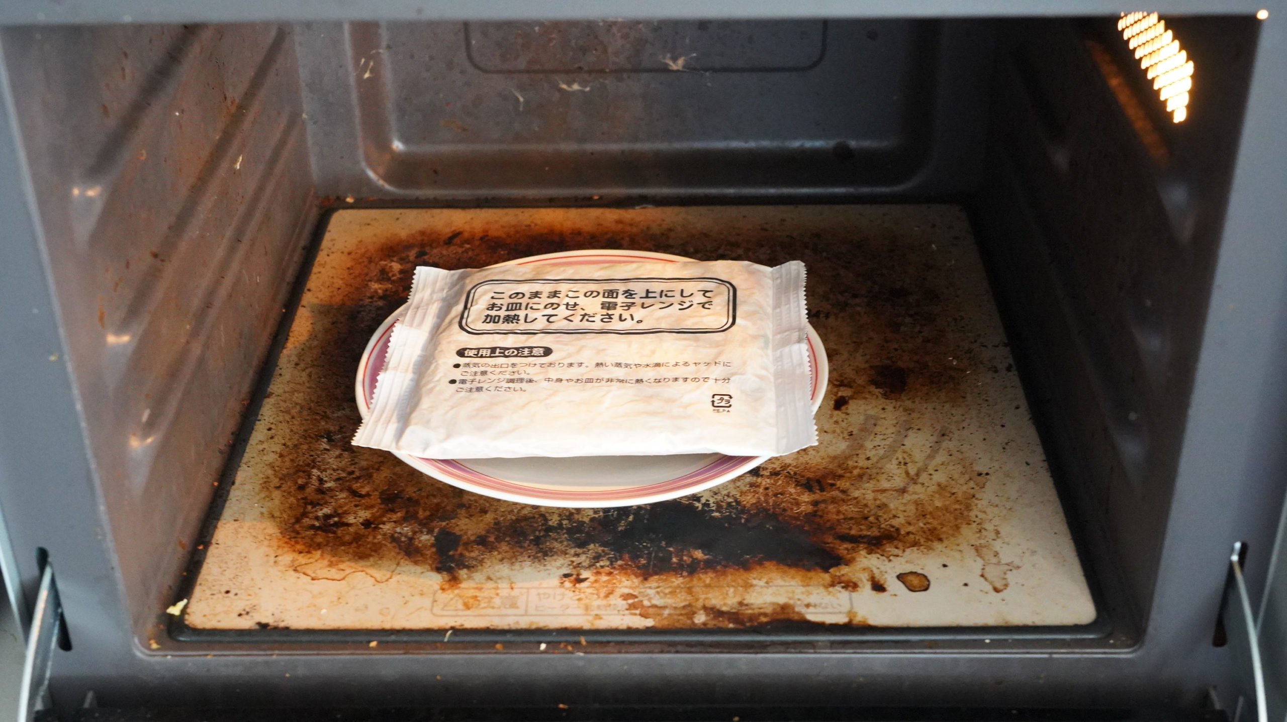 ローソンの冷凍食品「焼ビーフン」を電子レンジで加熱している写真