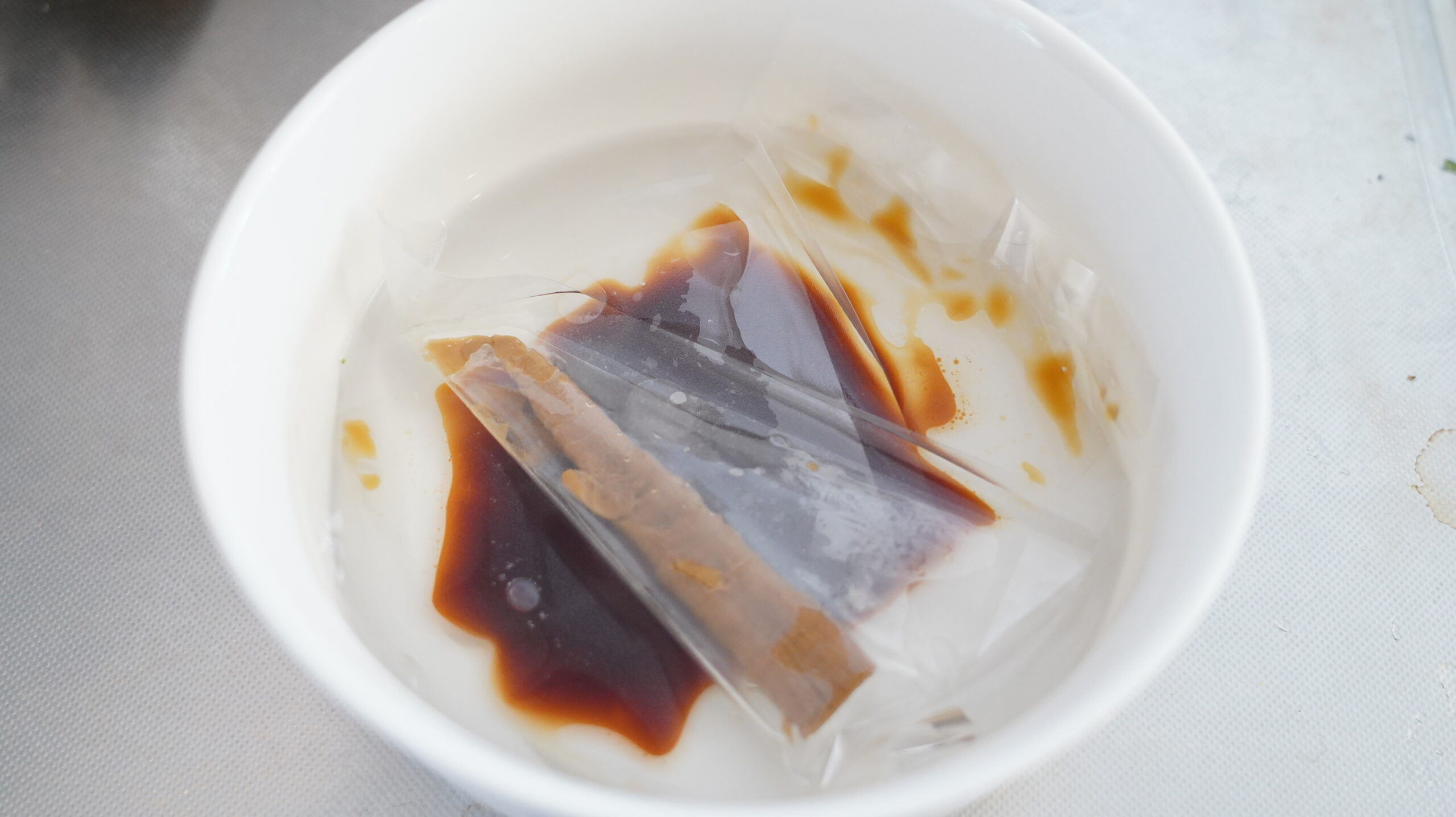 くそオヤジ最後のひとふりの「あさりラーメン」のオンライン通販・お取り寄せ用の冷凍食品のスープをお湯で温めている写真
