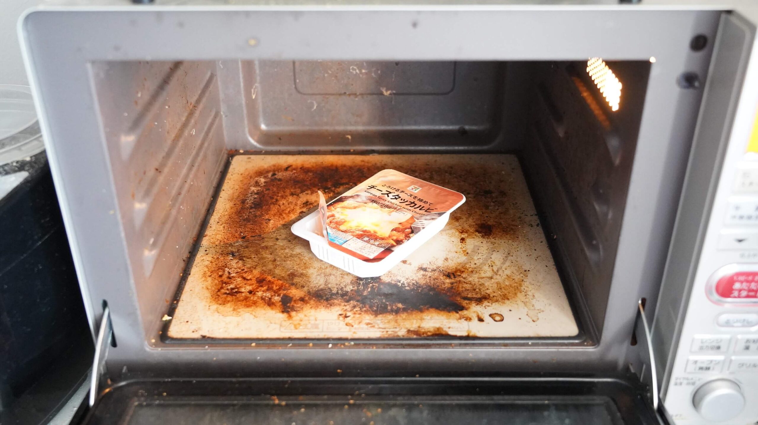 セブンイレブンの冷凍食品「とろけるチーズを絡めて・チーズダッカルビ」を電子レンジで加熱している写真