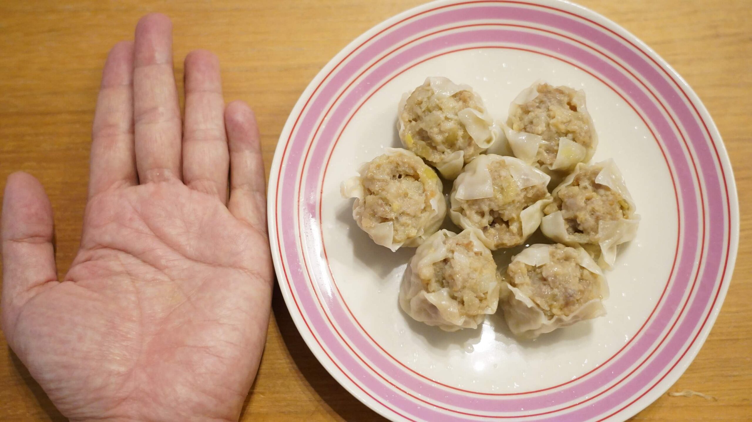 コストコのシューマイ冷凍食品「贅沢焼売」と私の手を比較した写真