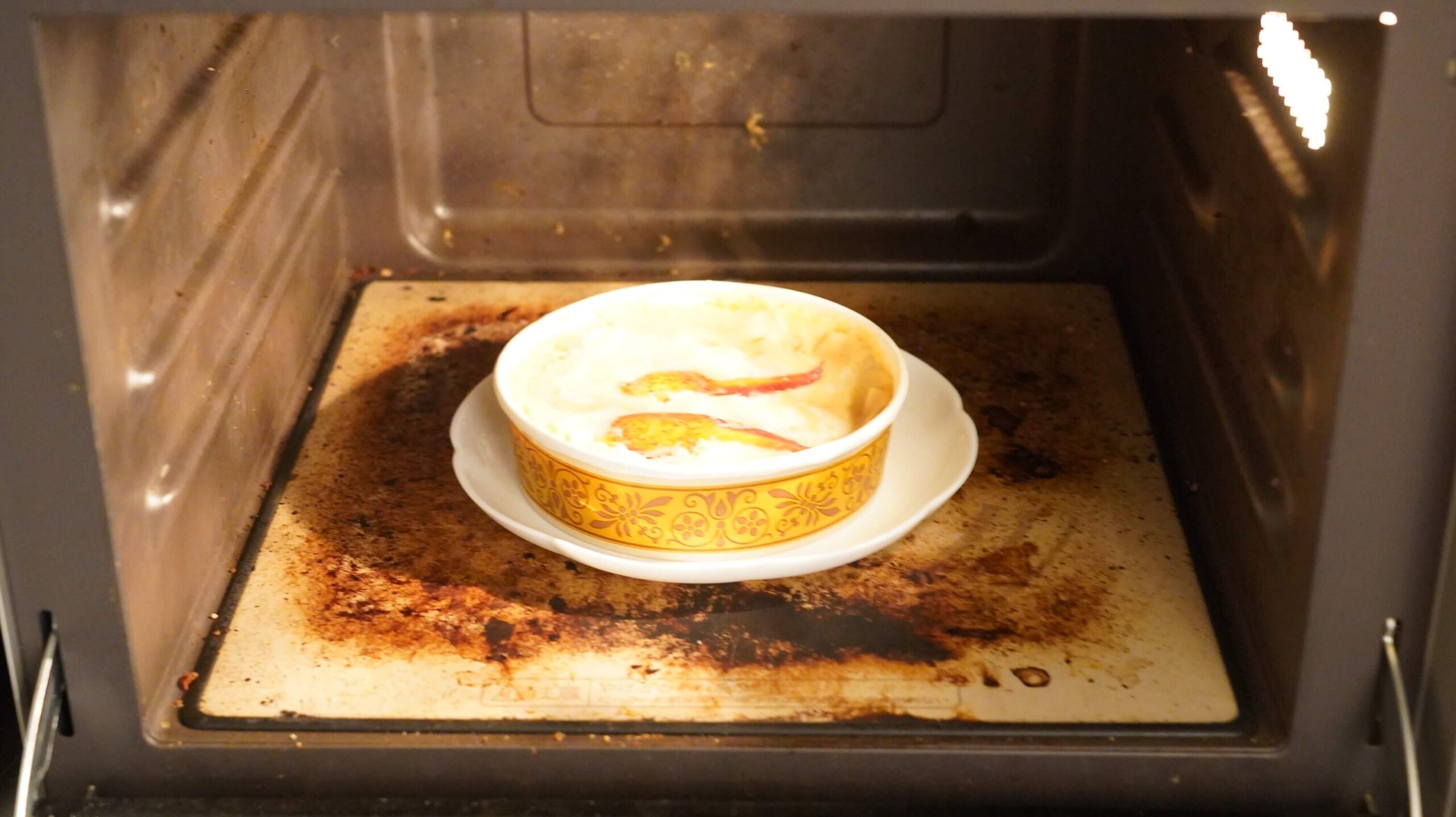 俺のフレンチの冷凍食品「オマール海老とズワイガニのペンネグラタン」を電子レンジで調理している写真