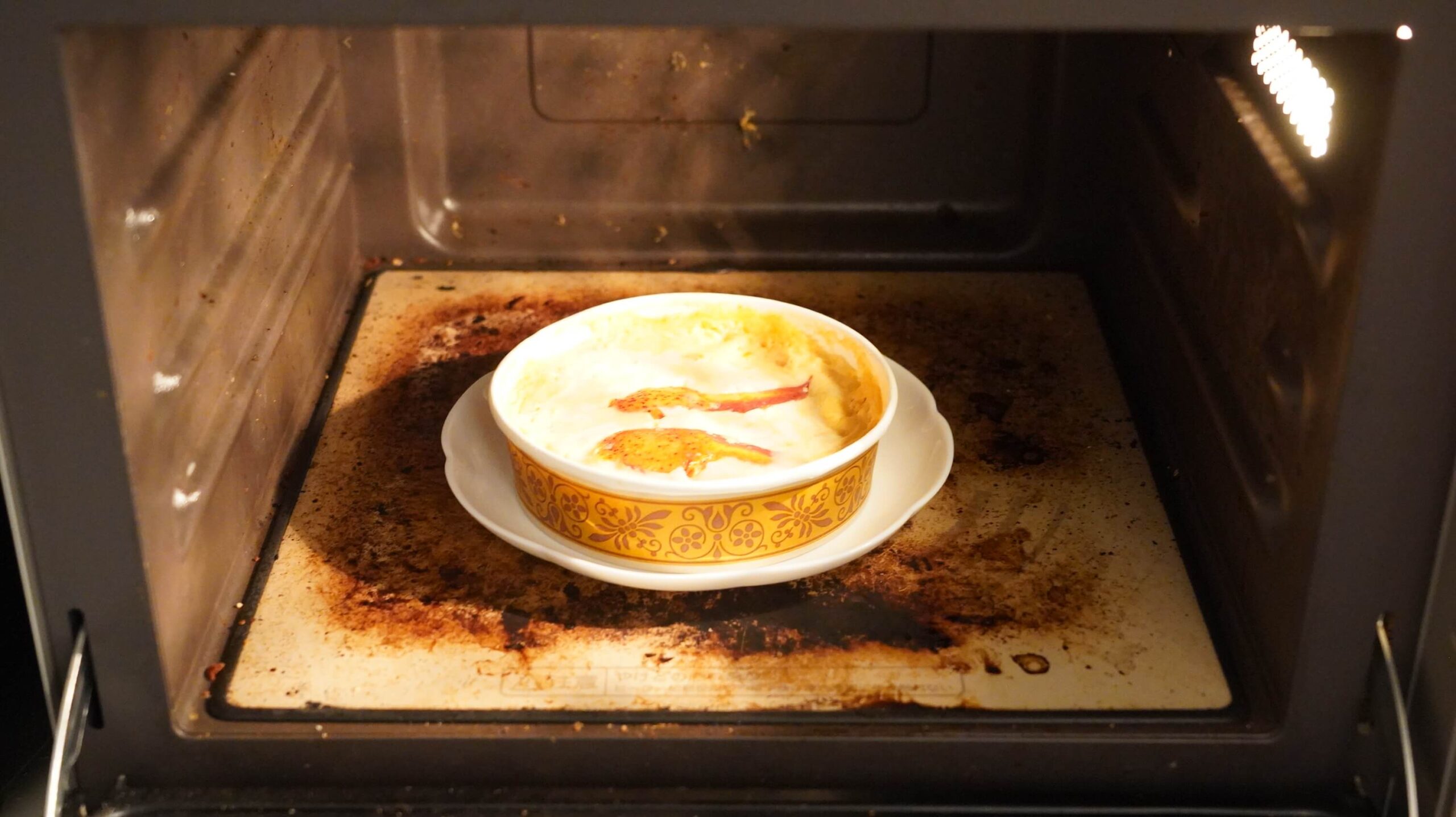 俺のフレンチの冷凍食品「オマール海老とズワイガニのペンネグラタン」を電子レンジで加熱している写真