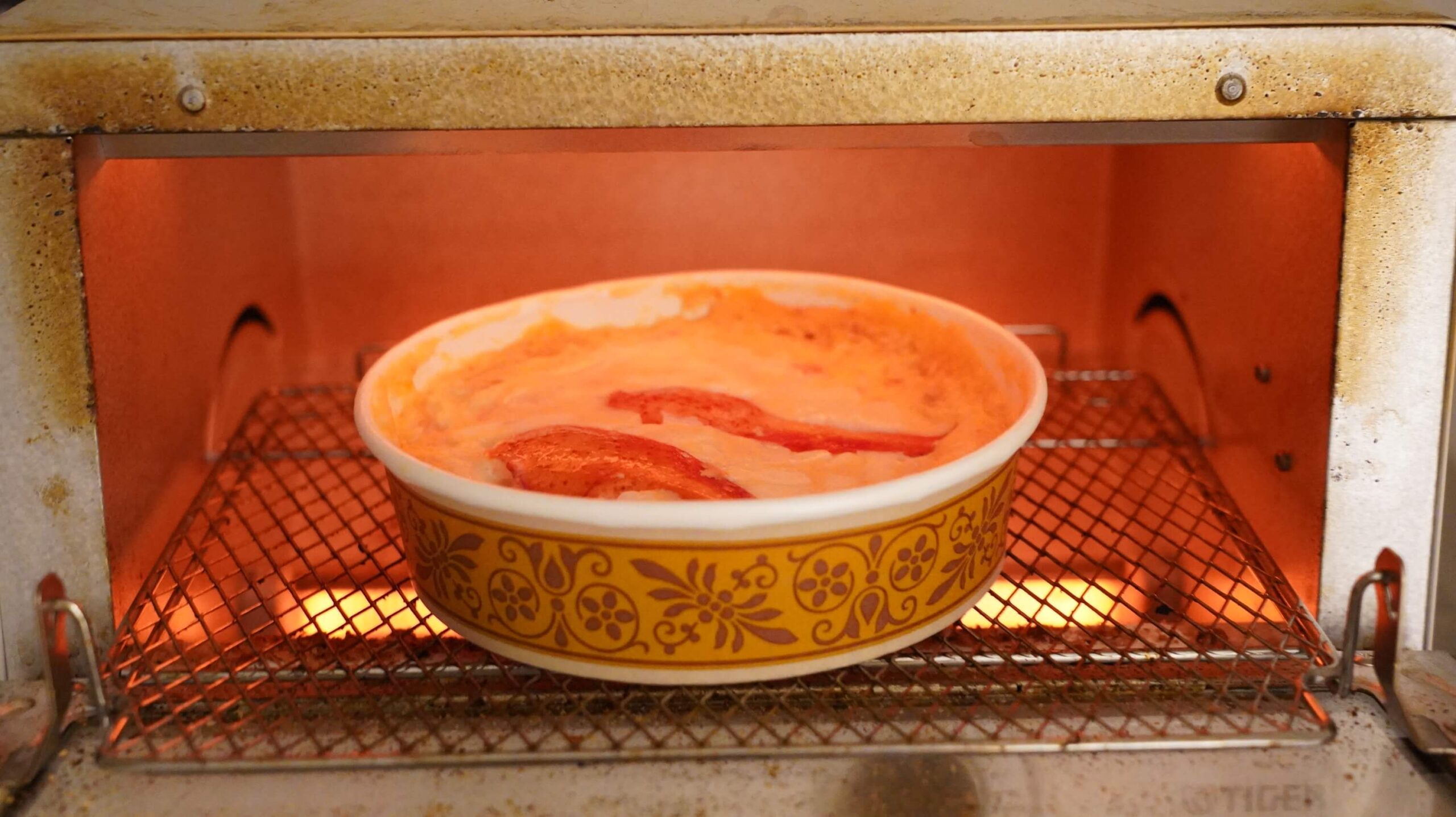 俺のフレンチの冷凍食品「オマール海老とズワイガニのペンネグラタン」をオーブントースターで加熱している写真