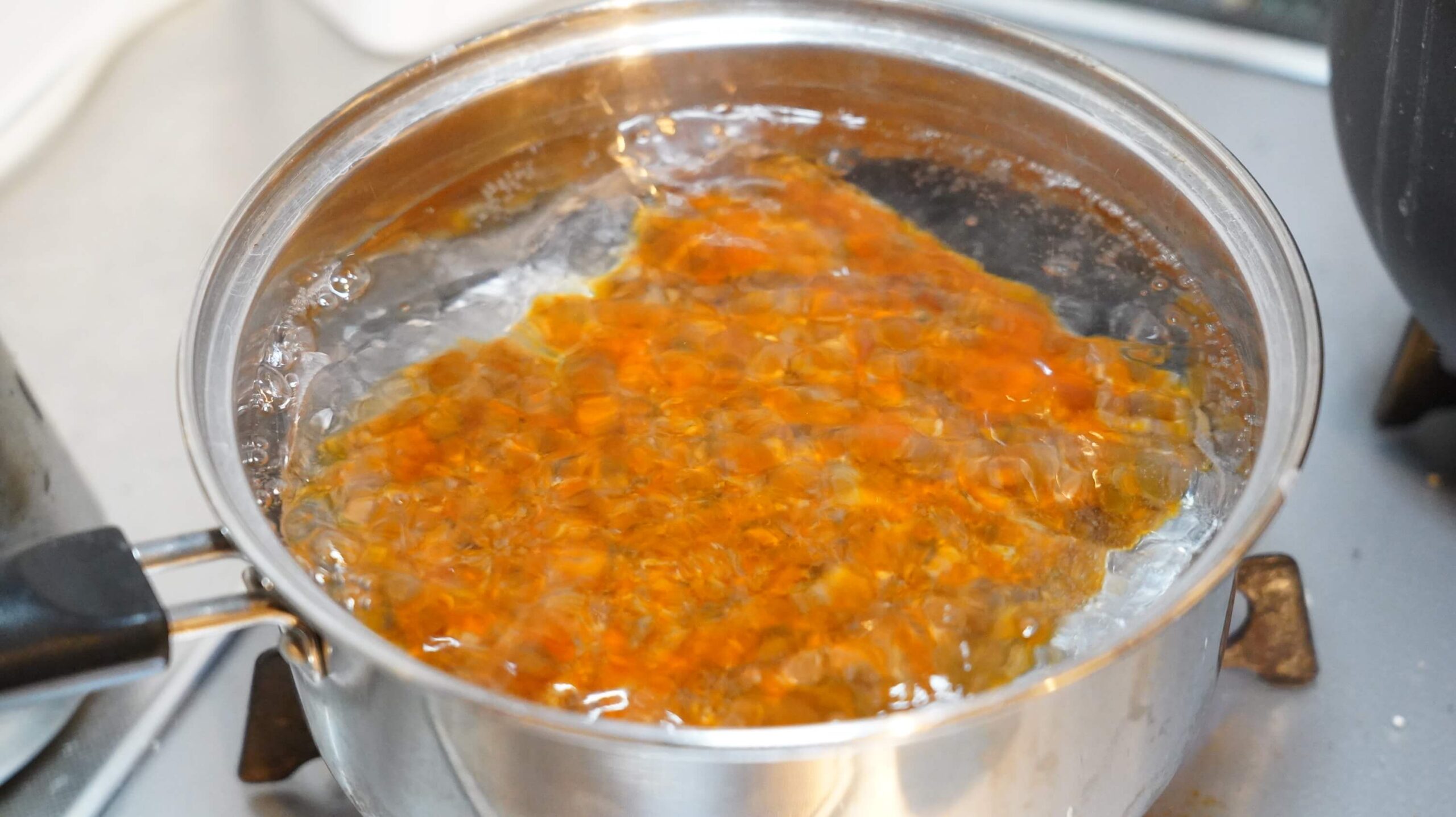 俺のイタリアンの冷凍食品「トリュフ薫るボロネーゼ」のソースを湯せんで調理している写真