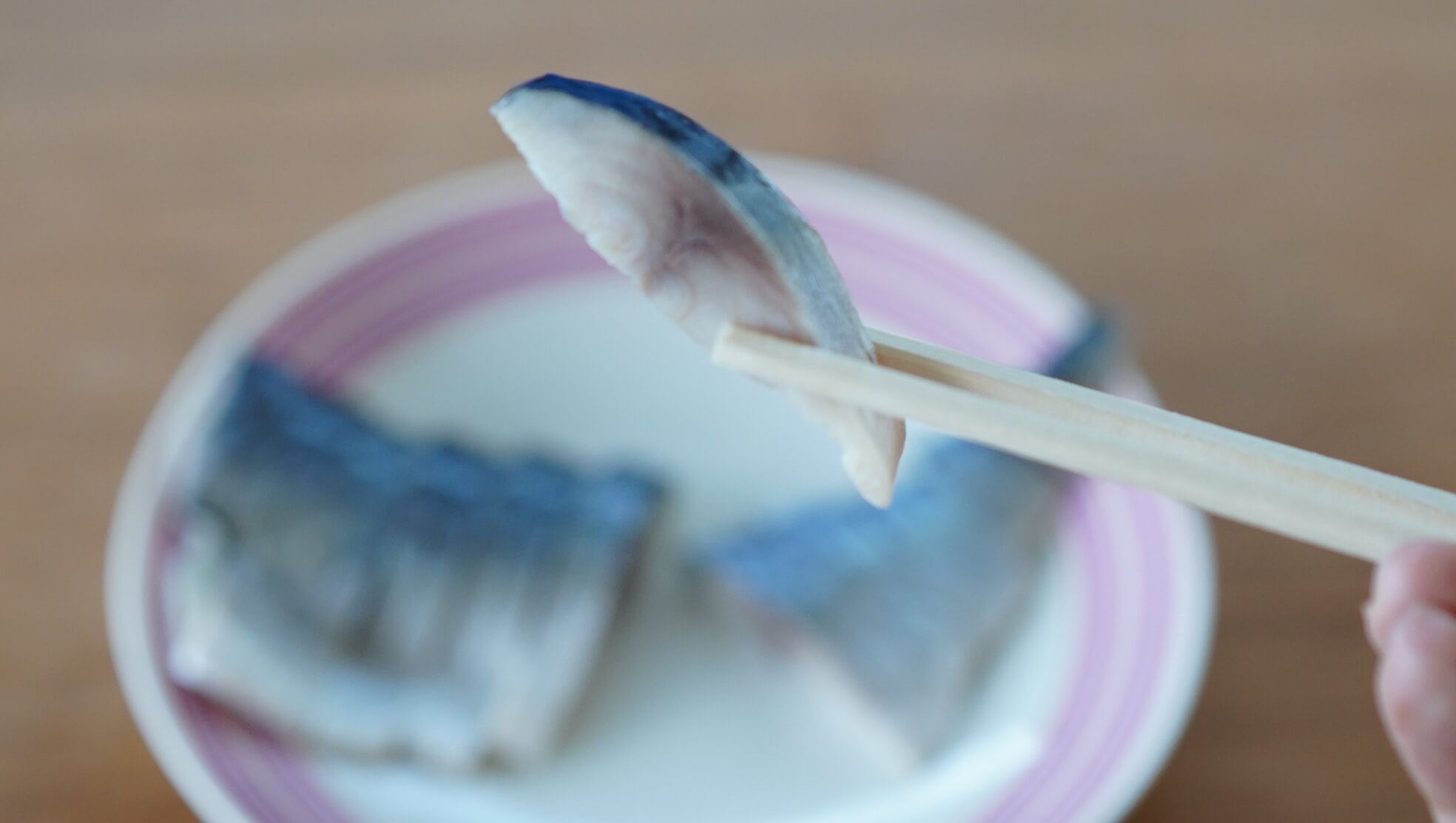 生協（コープ）の冷凍食品「国産素材・しめさば」の鯖を箸でつまんでいる写真