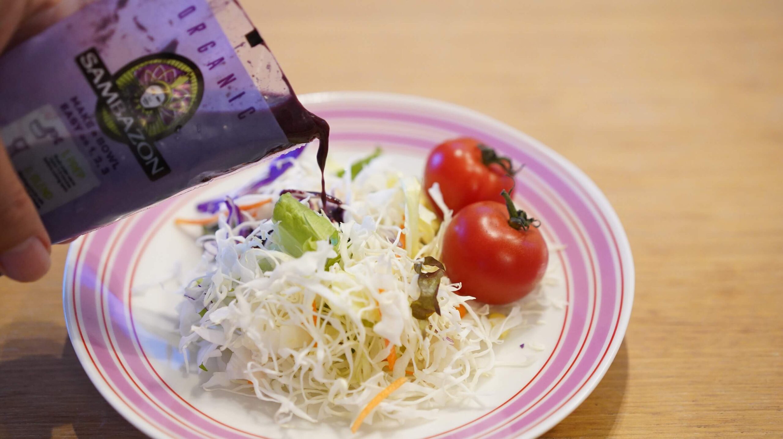 コストコの冷凍食品アサイー「サンバゾン・アサイースムージーパック」をサラダにかけている写真