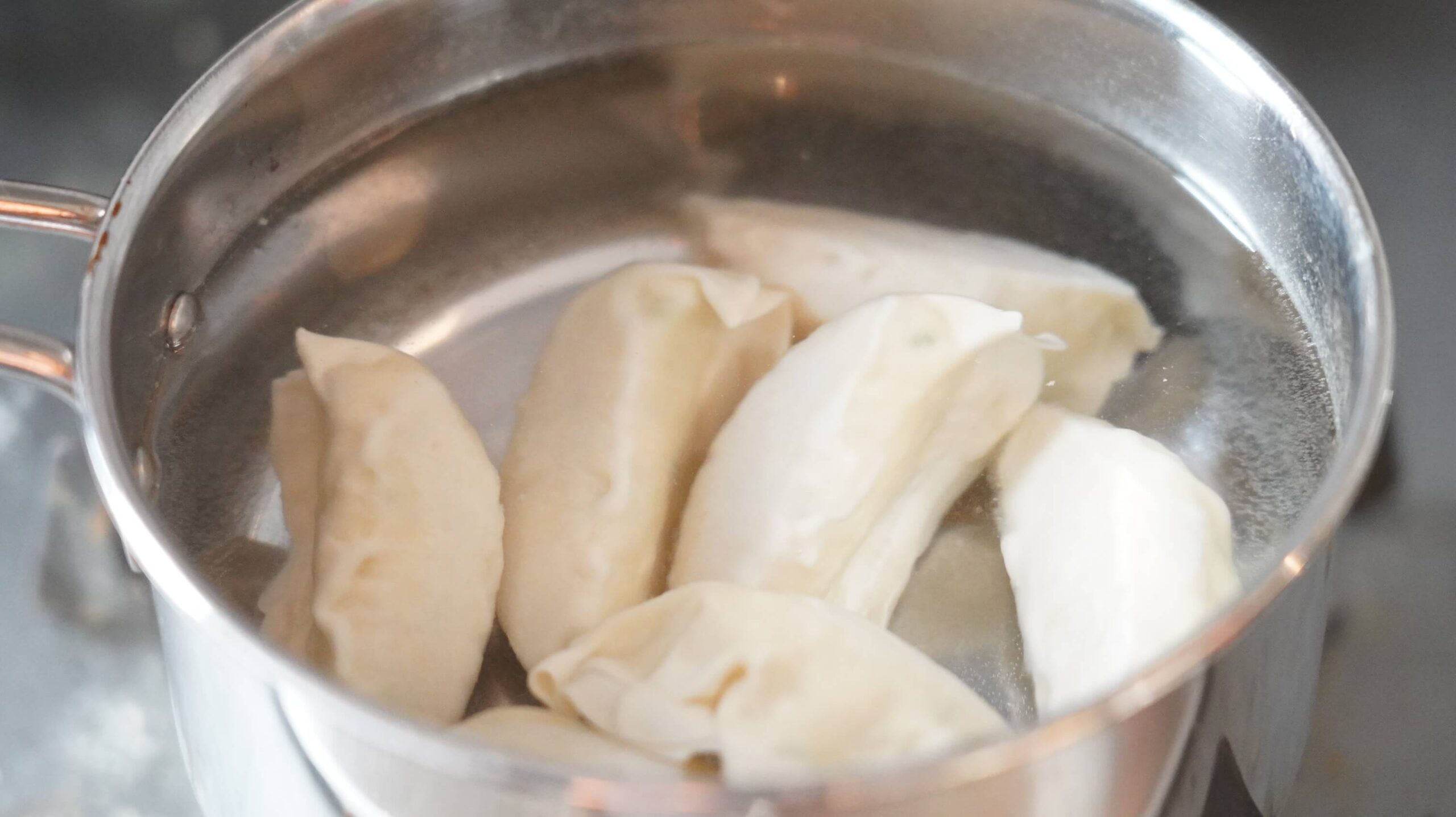 冷凍食品「マッスル餃子」を鍋でゆでている写真