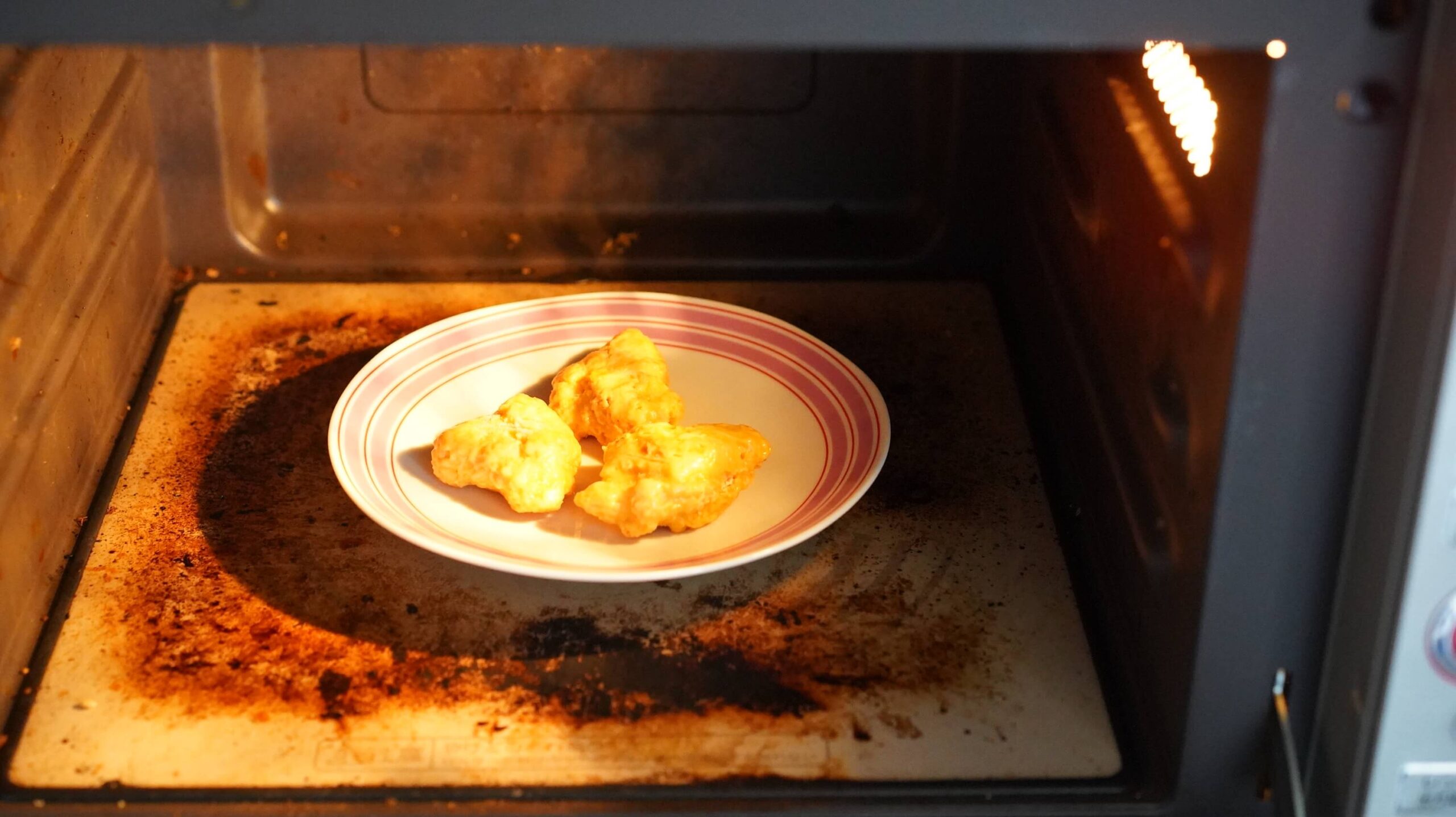 ニチレイの冷凍食品「ハニーマスタードチキン」を電子レンジで加熱している写真