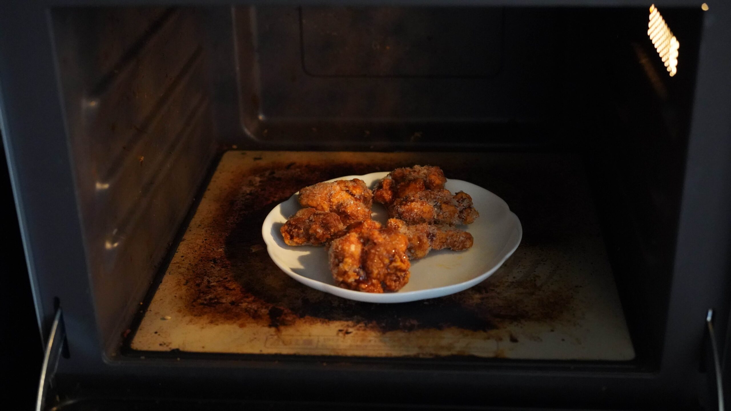 トップバリュ(TOPVALU)の冷凍食品「若鶏のたれづけ唐揚げ」を電子レンジで加熱している写真