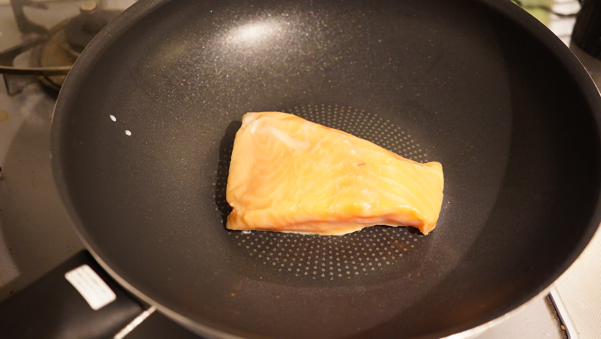 コストコの冷凍食品「アトランティック・サーモン」をフライパンで焼いている写真