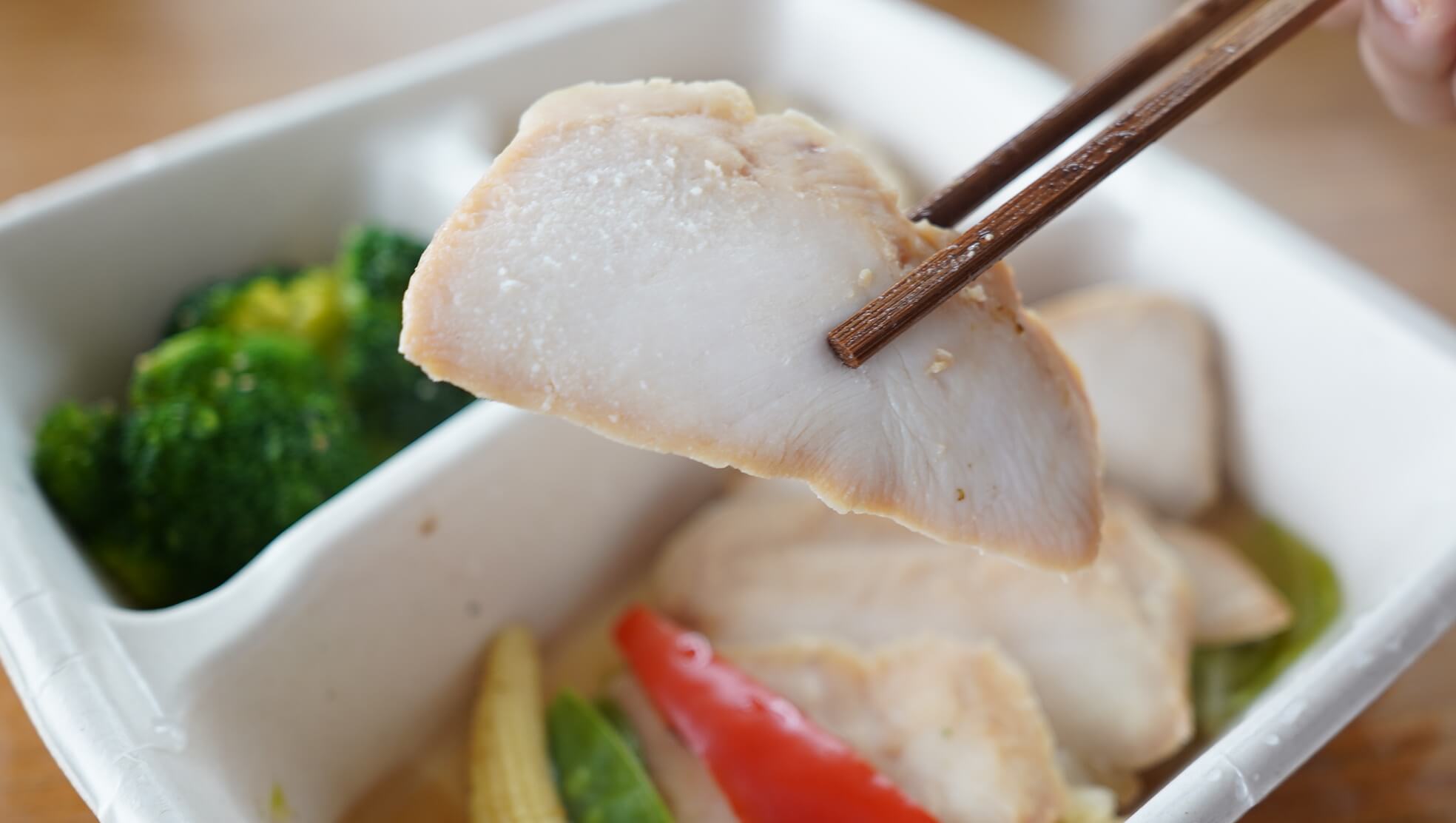 筋肉食堂DELIの「鶏ムネ肉のチャーシュー」を箸で持ち上げている写真