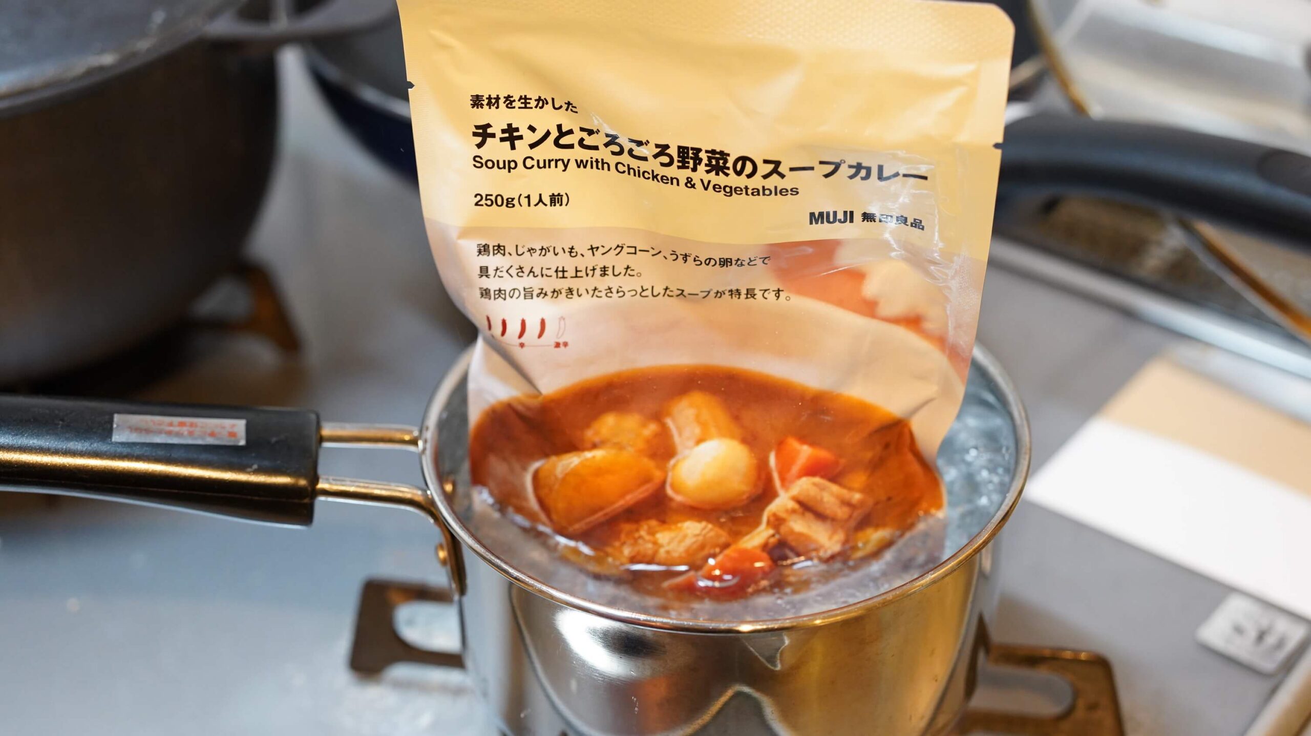 無印良品のカレー「チキンとごろごろ野菜のスープカレー」を湯煎で加熱している写真