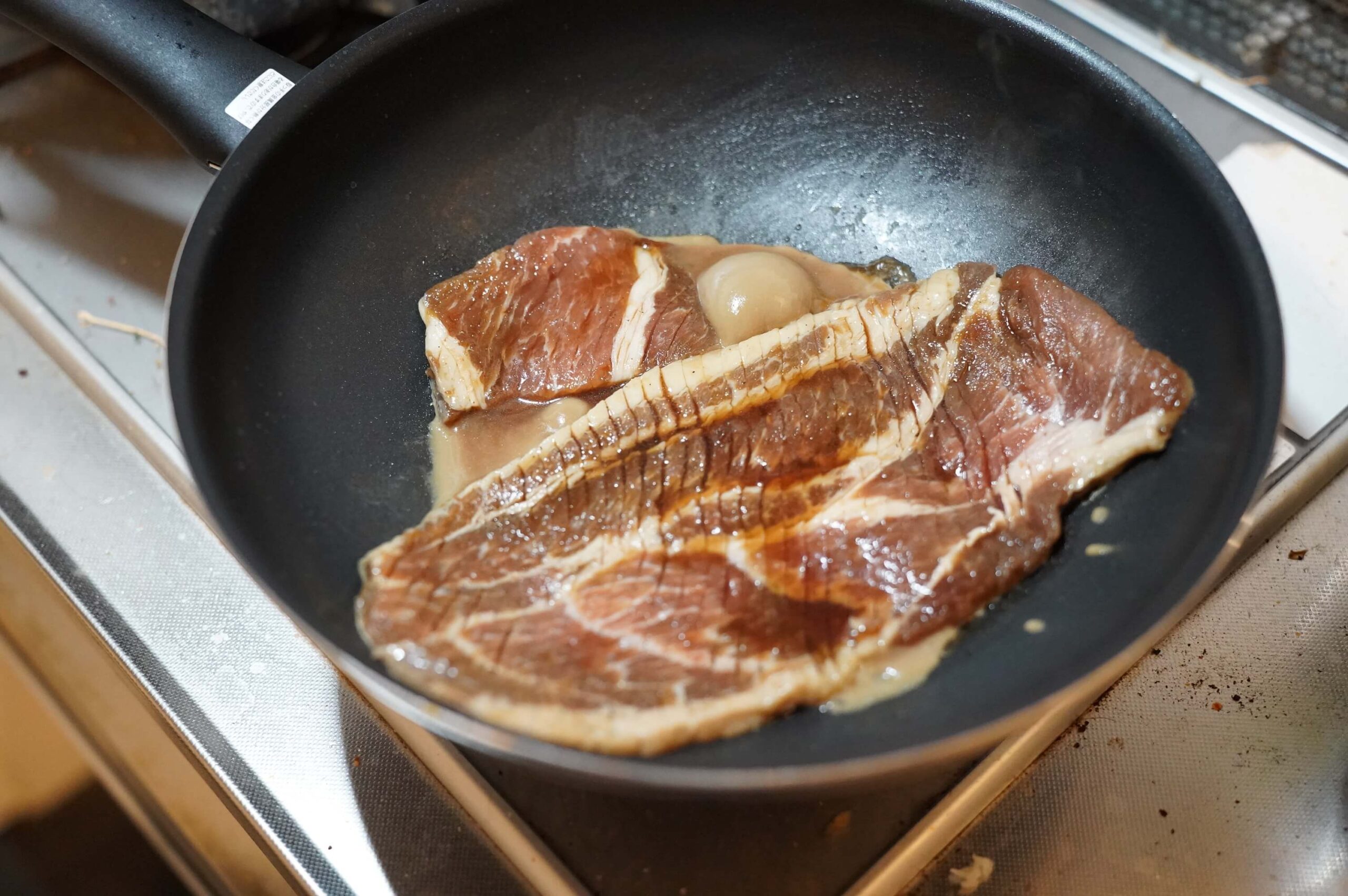 韓国料理「釜山熟成豚カルビ」をフライパンで調理している写真