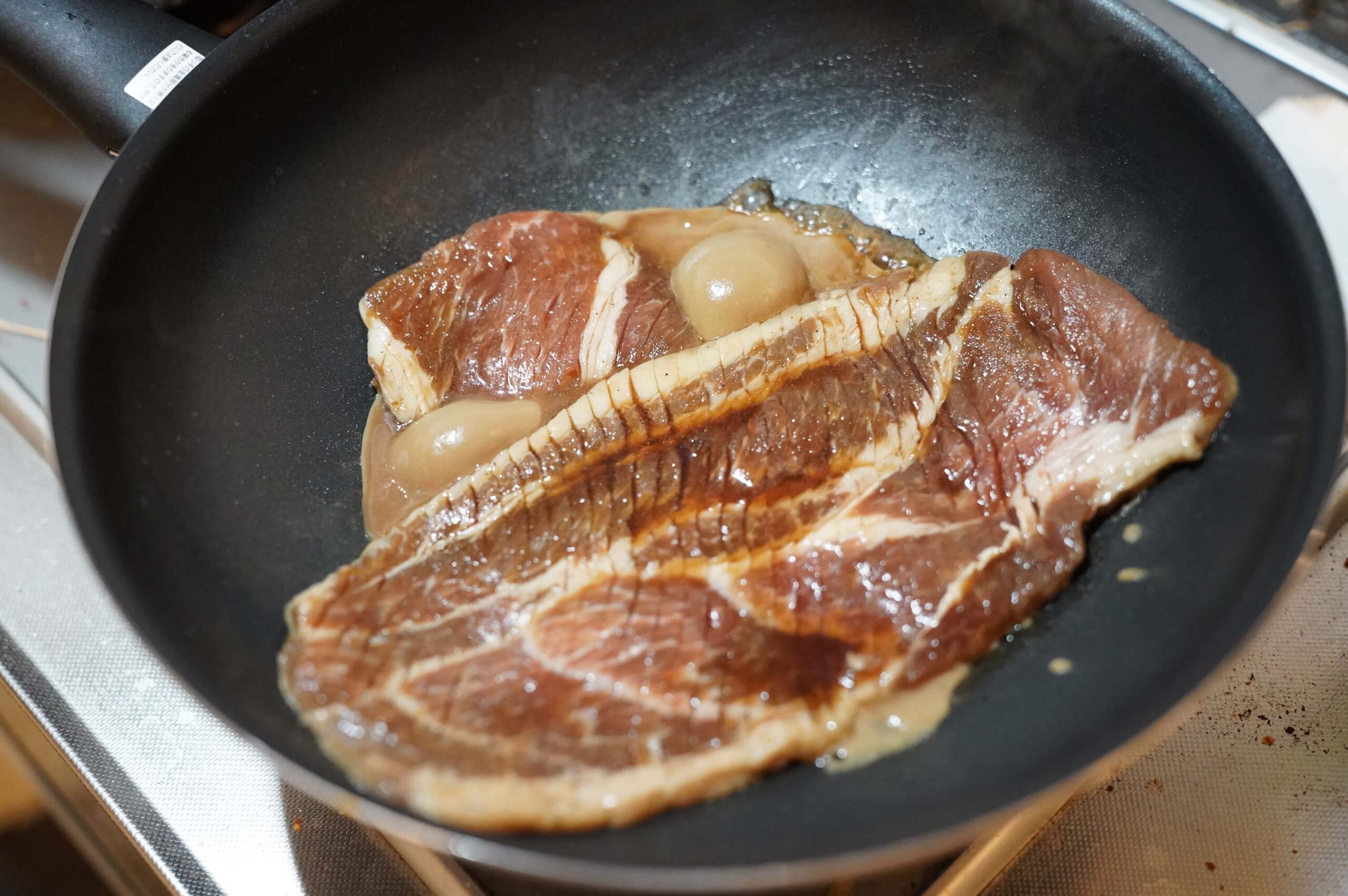 韓国料理「釜山熟成豚カルビ」を加熱している写真