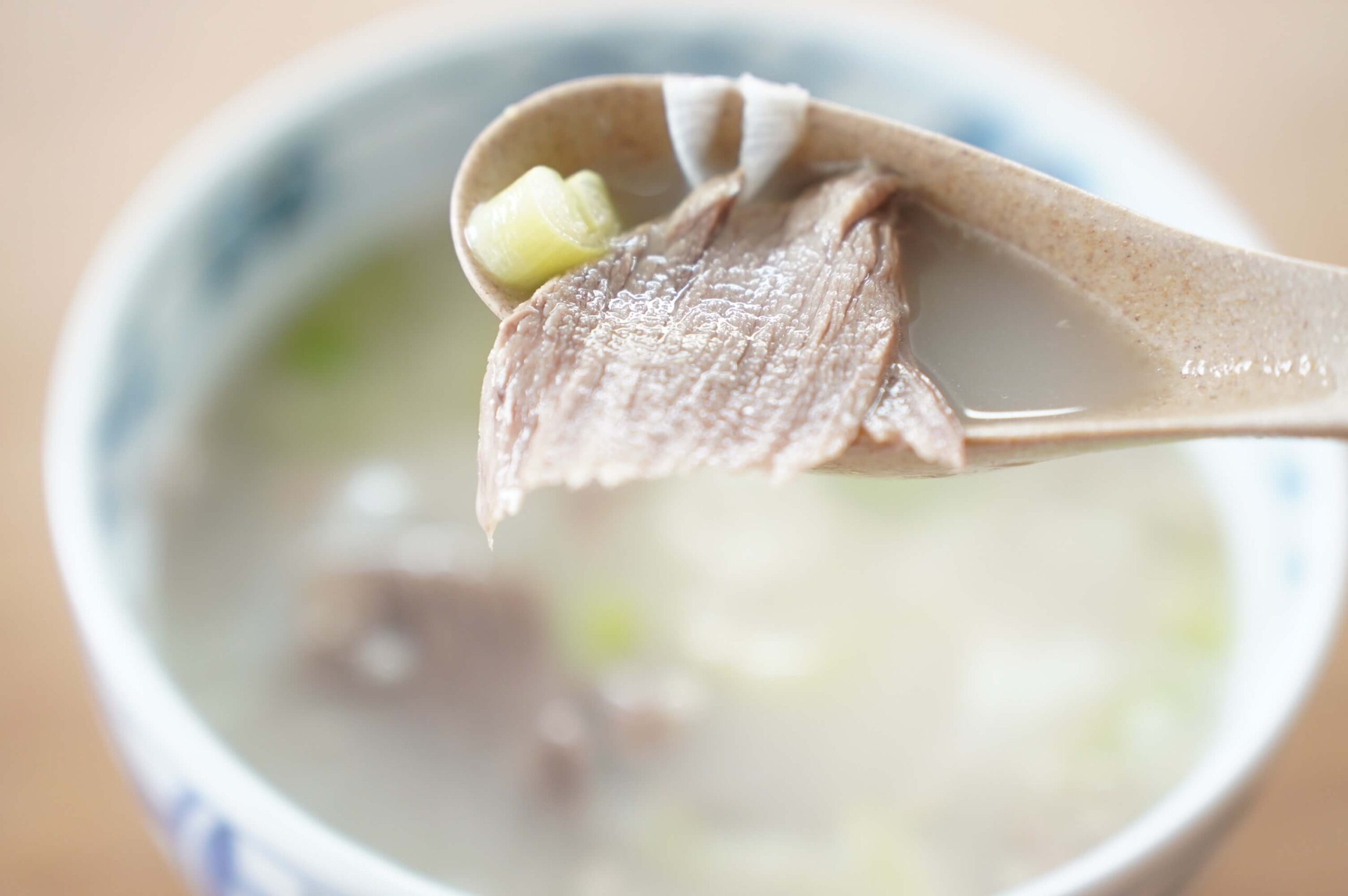 韓国料理「ソルロンタン」をスプーンですくっている写真