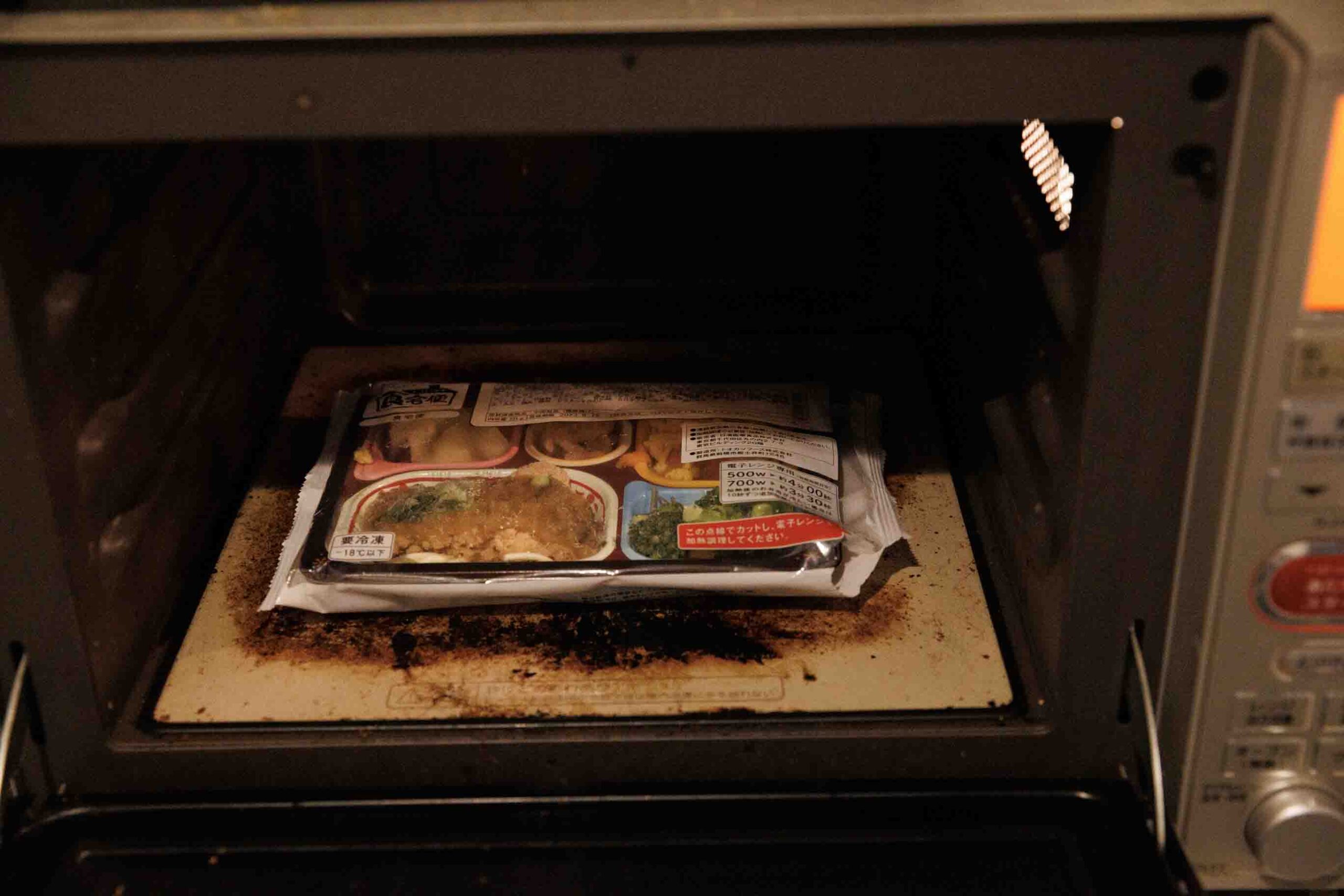 食宅便の「鶏唐揚げの葱甘酢がけ」を電子レンジで加熱している写真